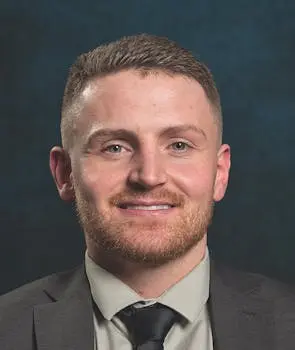 Portrait of a man in a suit smiling at the camera.