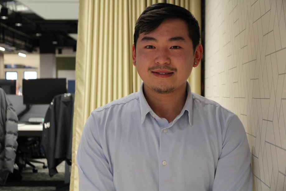Man wearing a light blue shirt smiles at the camera.