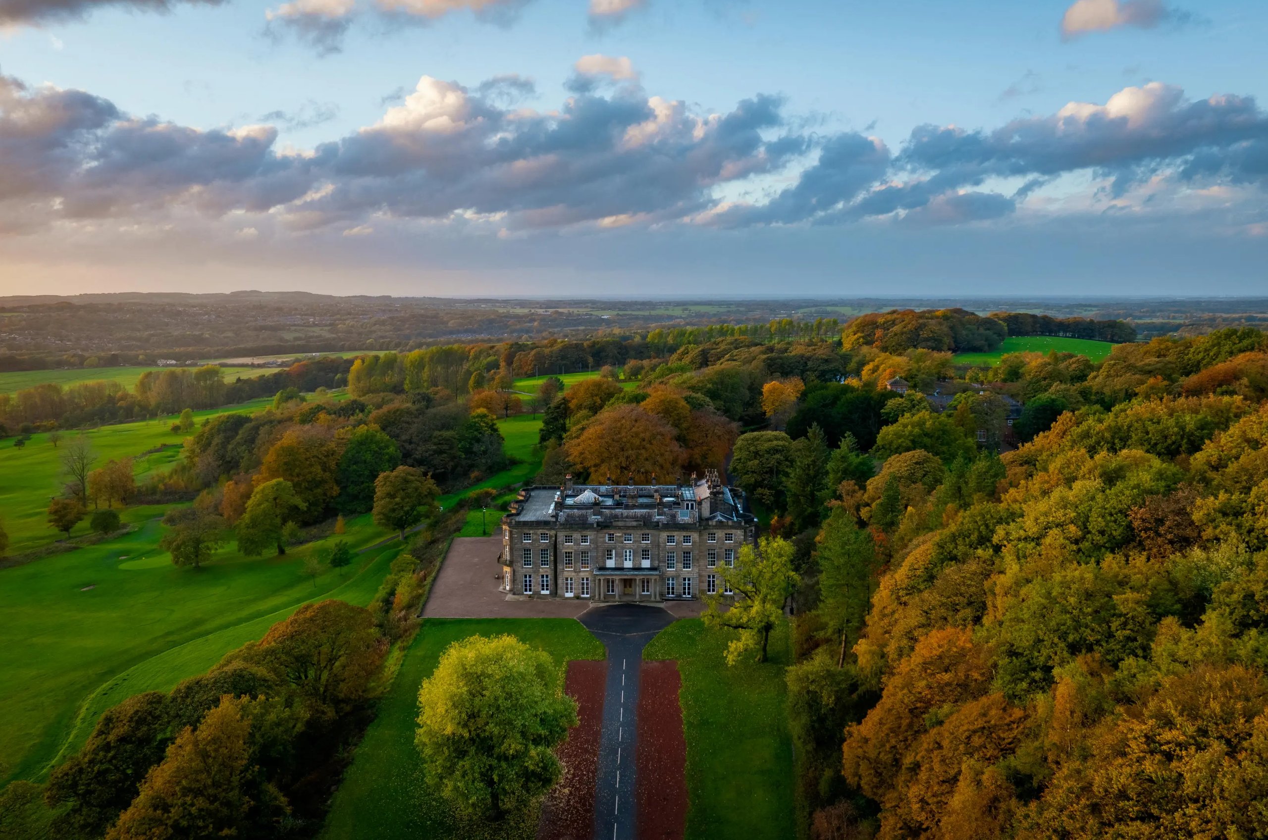 Aerial view of Haigh Hall, surrounded by green fields and trees.