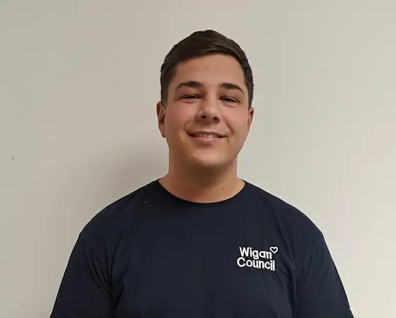 Man wearing black T-shirt with Wigan Council written on it.