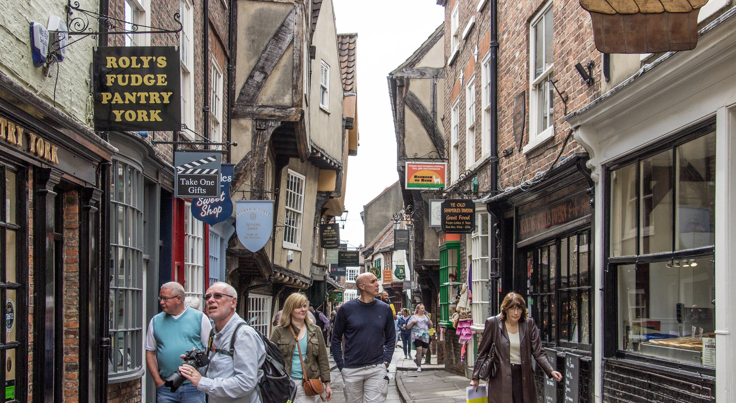 Shops and people on a narrow street in York, England.