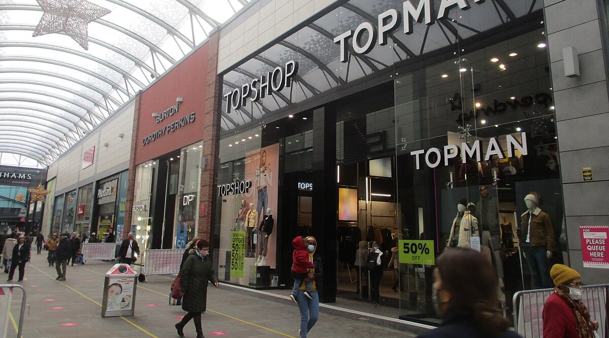 Shops including Topshop, Burton, and Dorothy Perkins. People walking.