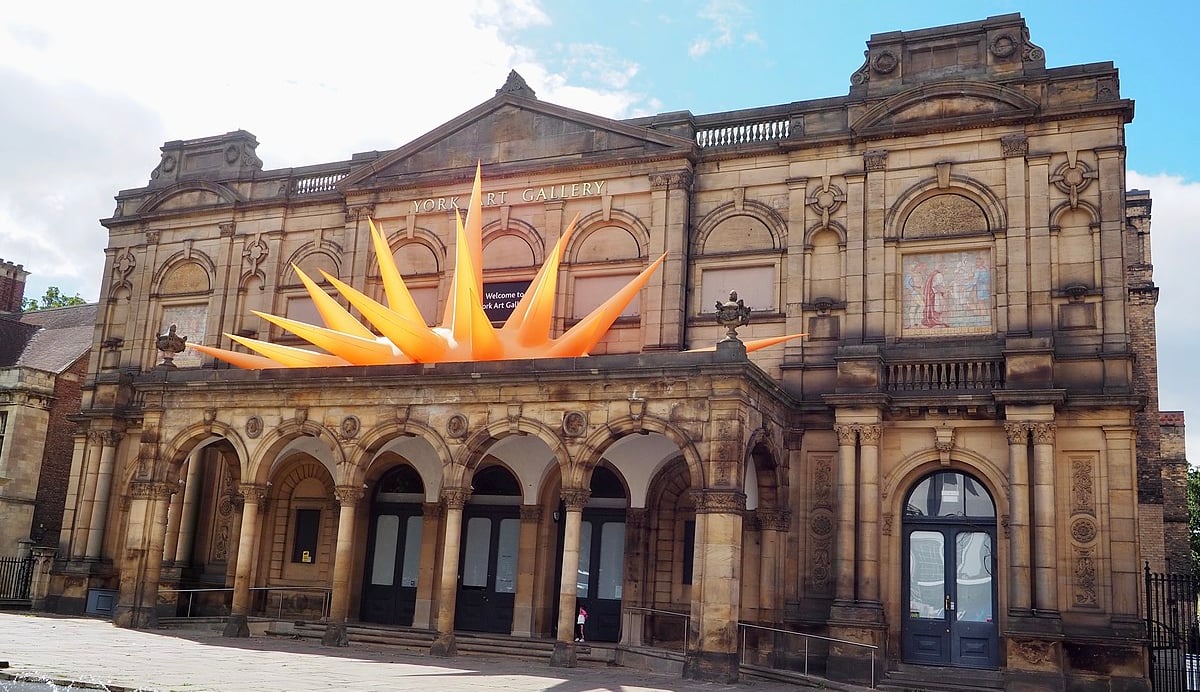 Exterior of the York Art Gallery building with an orange inflatable on the roof.