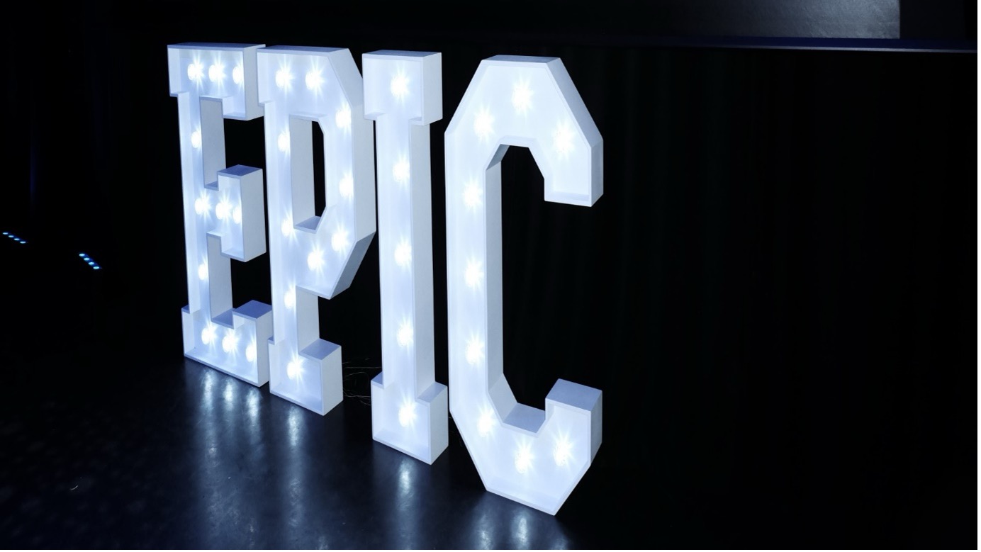 Illuminated white "EPIC" sign on a dark background.