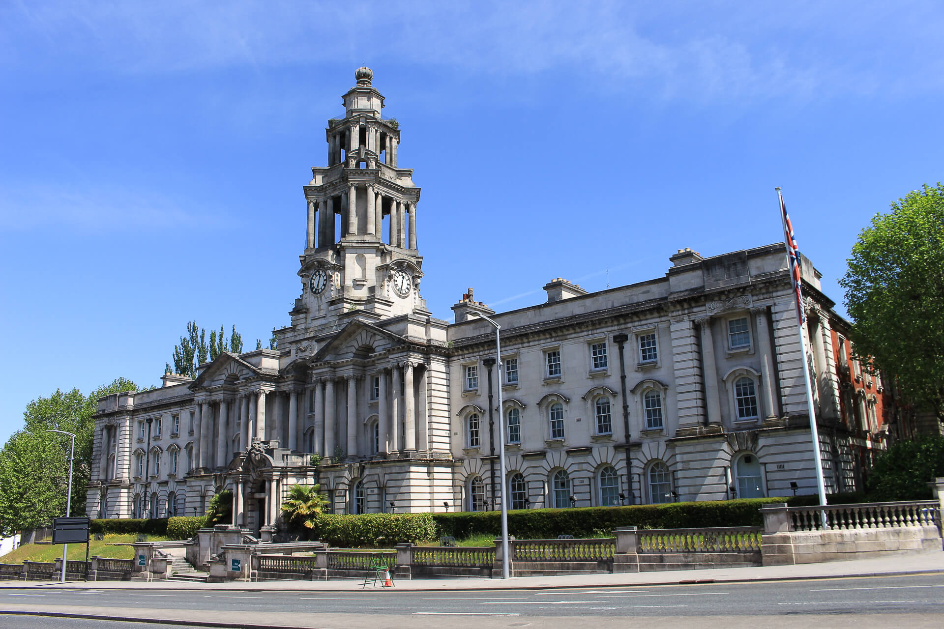Building with clock tower and British flag.