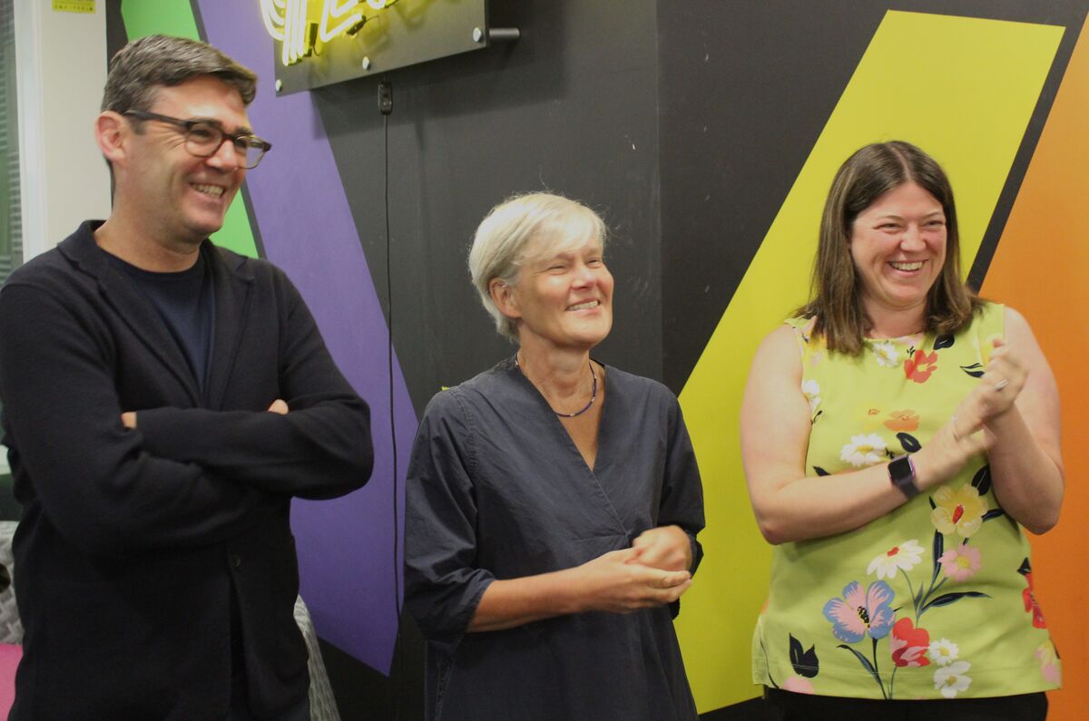 Three people smiling; one clapping.