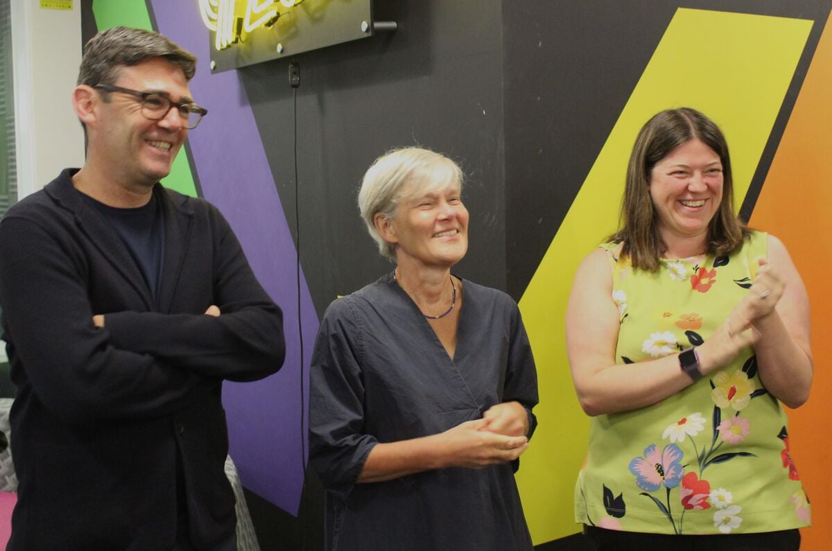 Three people smiling; one clapping.