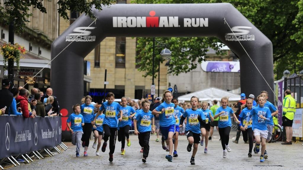 Children running in a race, Iron Man Run sign.