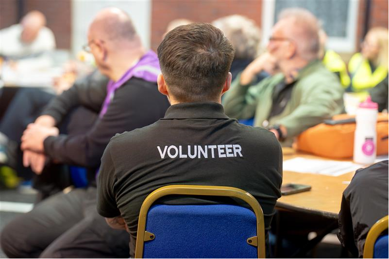 Person wearing a black shirt with "VOLUNTEER" on the back.
