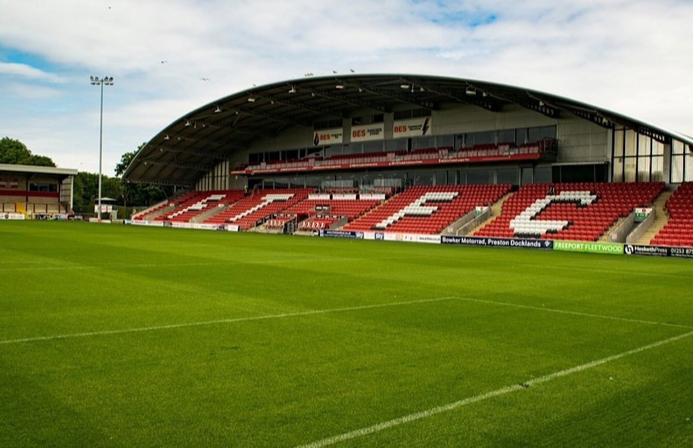 Stadium with seating and grass field.