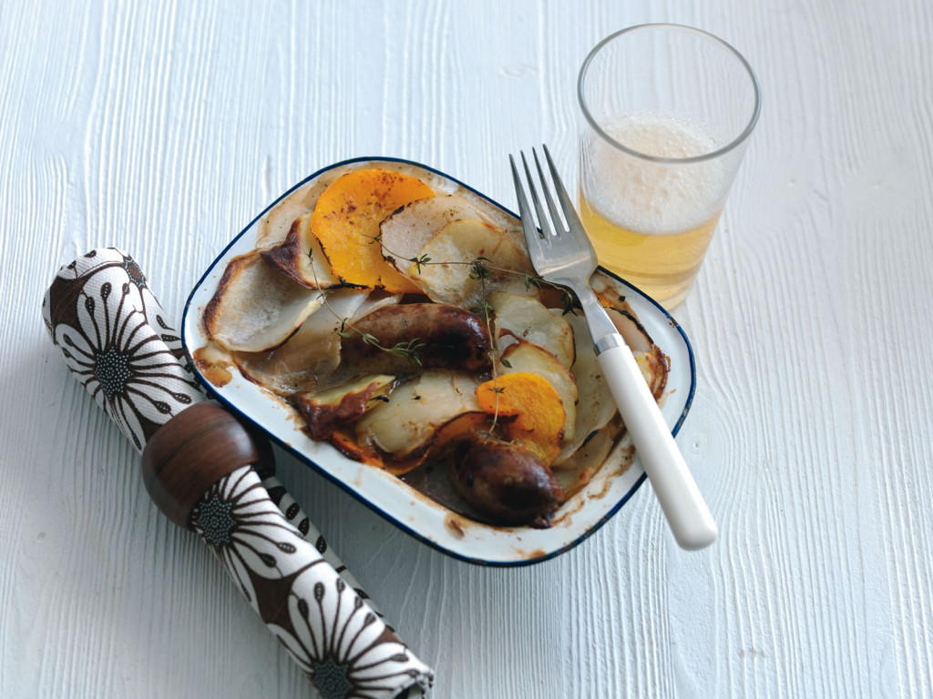 Lancashire hotpot with sausage, beer, and a napkin.