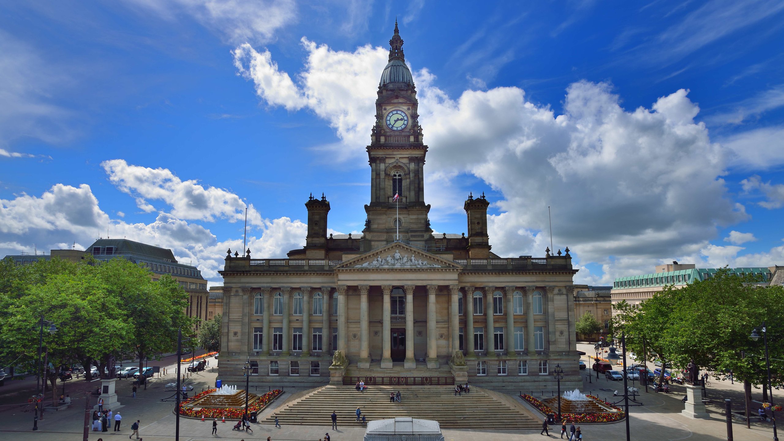 View of a town hall building and public square with people.