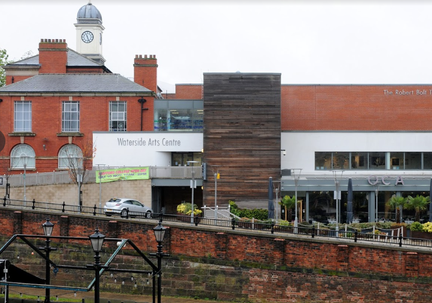 Exterior view of the Waterside Arts Centre with a clock tower and a restaurant.