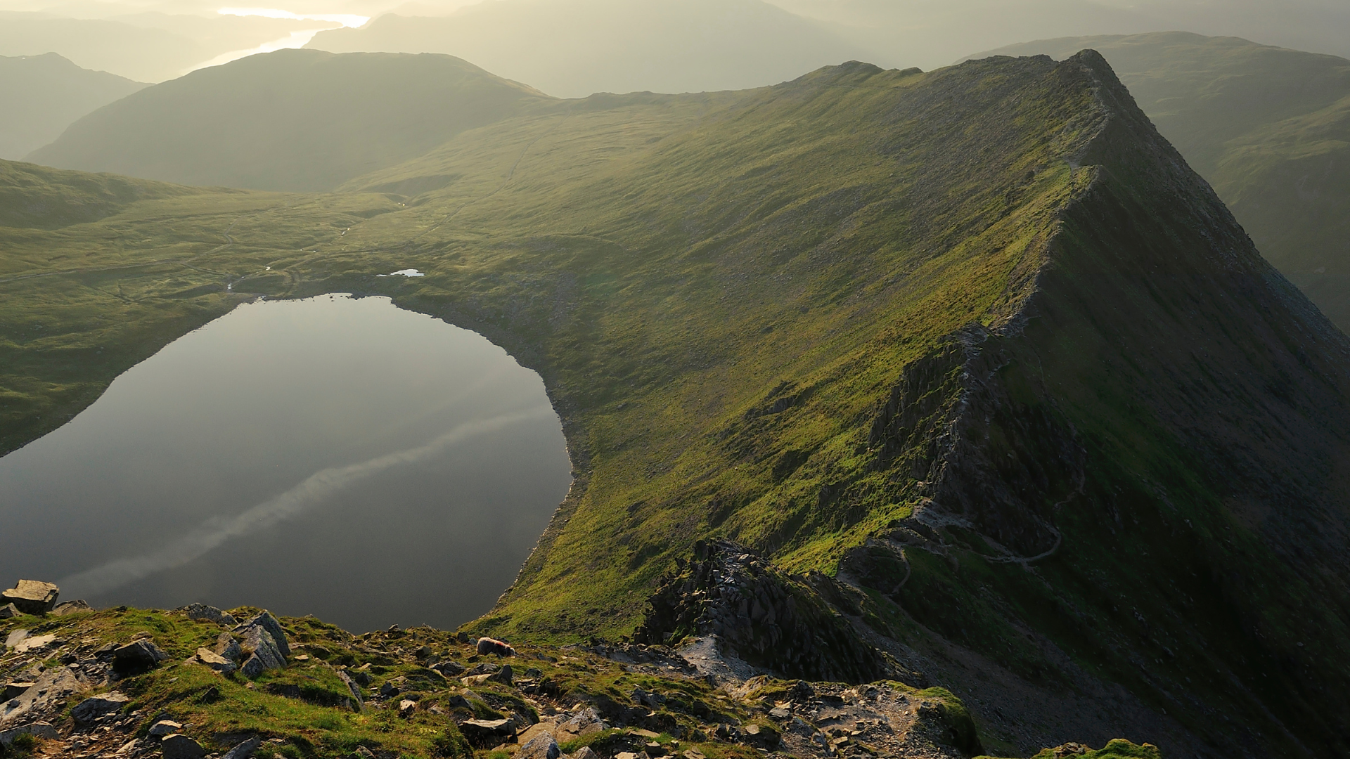 View of lake and mountain range with path and water.