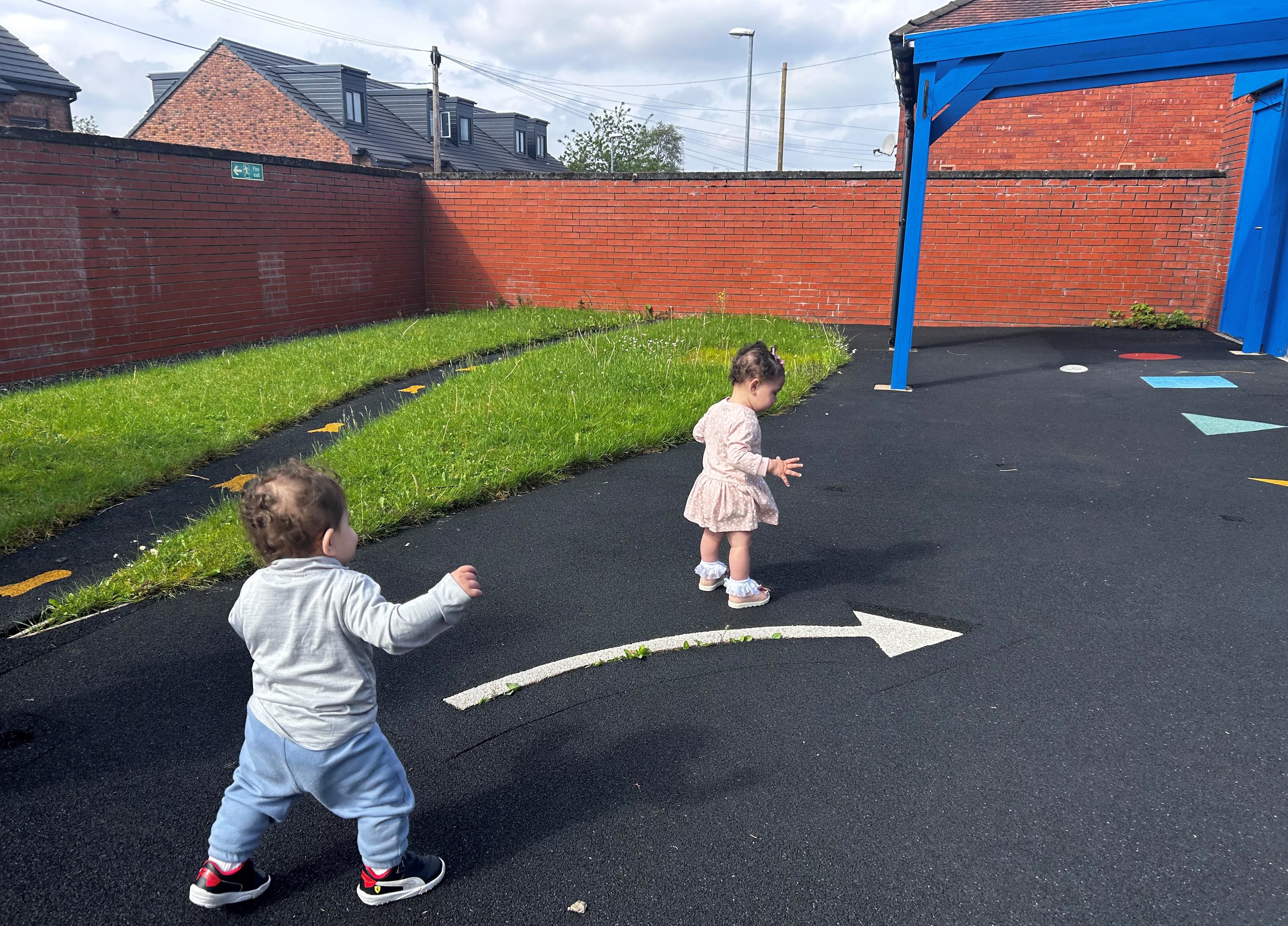 Two toddlers playing on a playground.