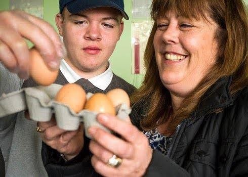 People holding eggs and smiling.