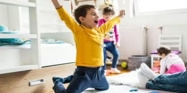 Boy celebrating a win while playing board games with family.