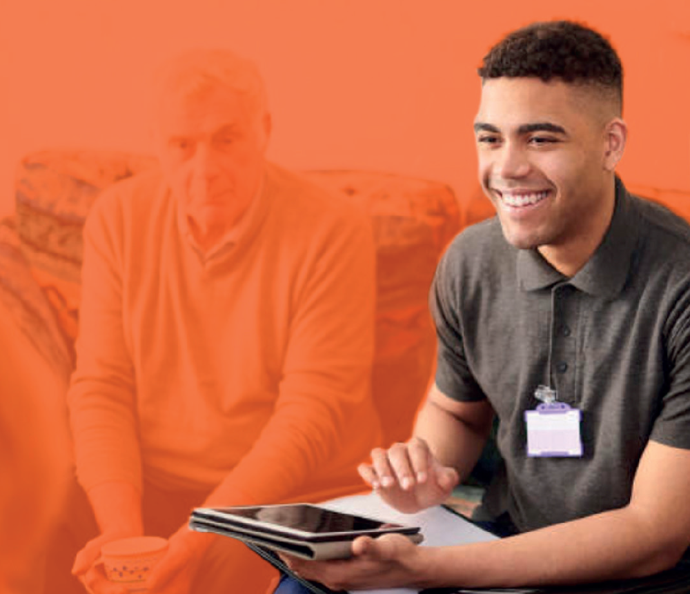 Young man with tablet, older man in background.