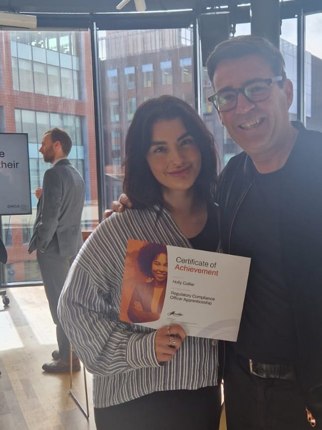 Woman with certificate and man smiling.