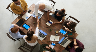 picture of a group of people sat around a desk having a meeting