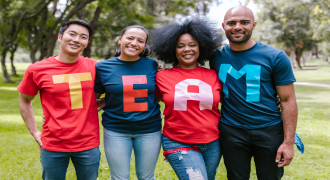 picture of four people wearing T-shirts that spell out the word team